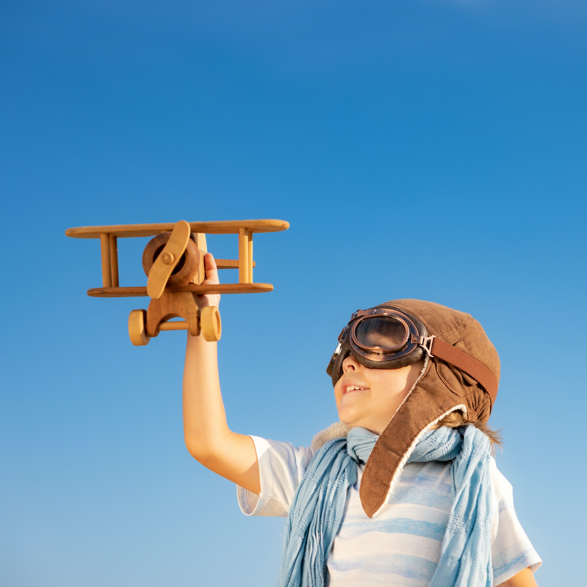 Happy child playing with toy airplane